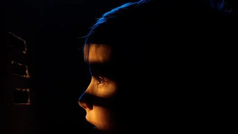 Child looking through blinds observing something Stock Photos