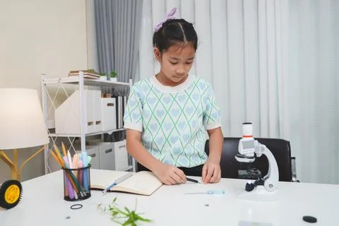 Child looking through microscope on white background. Kid scientist learning Stock Photos