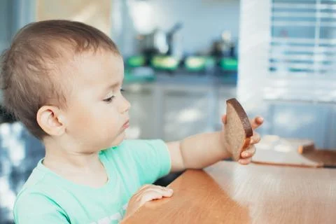 The child looks at the bread Stock Photos