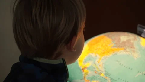 Child looks at a bright globe Stock Footage 178939622
