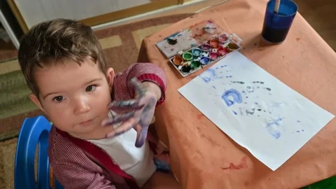 A child looks at the camera and shows his painted hand close-up Stock Footage 172591096