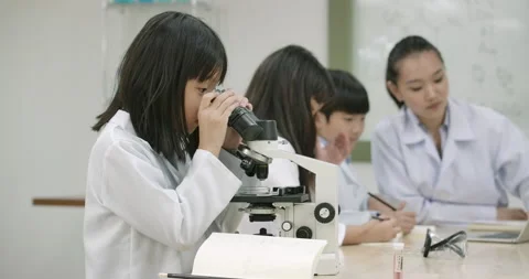 Child looks into microscope in Laboratory School Classroom. Video stock 153580498
