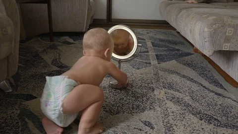 Child looks in the mirror at himself hd Video stock 80241340