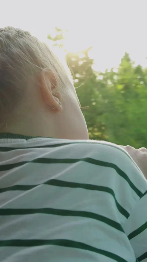 The child looks out the window during a trip. The girl enjoys the view from the Stock Footage 294817102