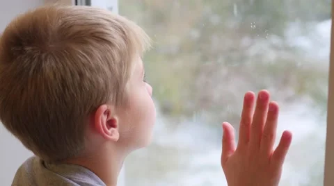 A child looks out the window at the snowfall Vidéo 68618768