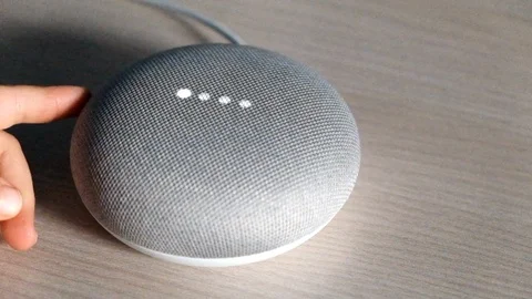 A child lower the volume of Google home in slow motion Stock Footage 120630639