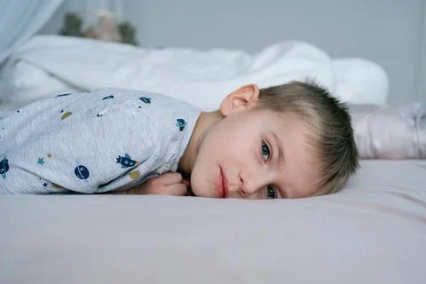 Child lying on bed looking at camera Foto stock