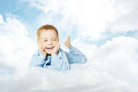 Child lying down on cloud pillow over sky background Stock Photos