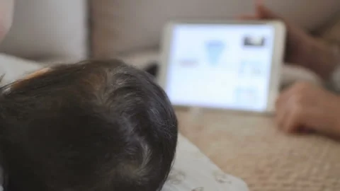 Child lying down watching cartoons on mobile tablet Stock Footage 88244435