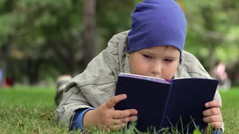 A child is lying on the grass in the park. Video stock 151628672