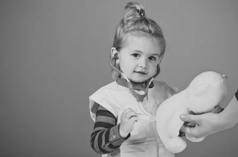 Child make injection to teddy bear in mothers hand Stock Photos