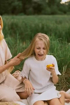Child makes a disgusted face while eating a slice of lemon outdoors Stock Photos