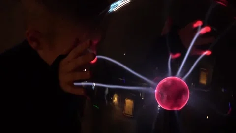 A child makes experiments on an electric plasma ball. Stock Footage 194132742