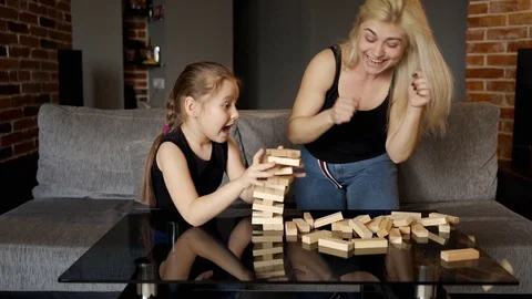 Child makes her move in game and tower crumbled and falling down. Slow motion Stock Footage 128422994