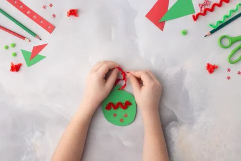 The child makes a paper Christmas decoration. Made with his own hands. Step.. Stock Photos