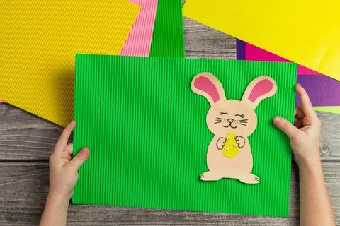 A child makes a postcard with an Easter bunny with his own hands. Applicati.. Stock Photos
