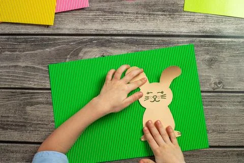 A child makes a postcard with an Easter bunny with his own hands. Application Stock Photos