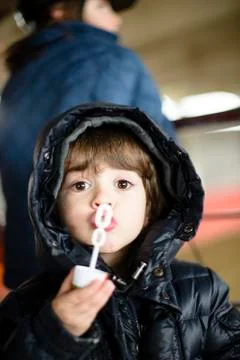 Child makes soap bubbles in winter Stock Photos