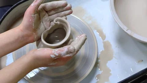 Child making ceramic vase on rotating pottery wheel at workshop. Creativity. Stock Footage 304791444