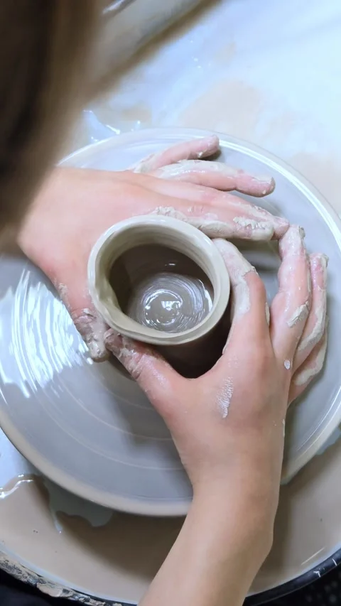 Child making ceramic vase on rotating pottery wheel at workshop. Creativity. Stock Footage 304953619