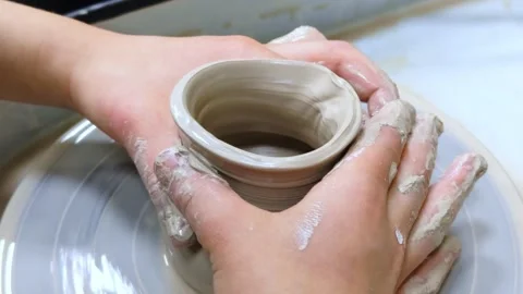 Child making ceramic vase on rotating pottery wheel at workshop. Creativity. Stock Footage 305061999