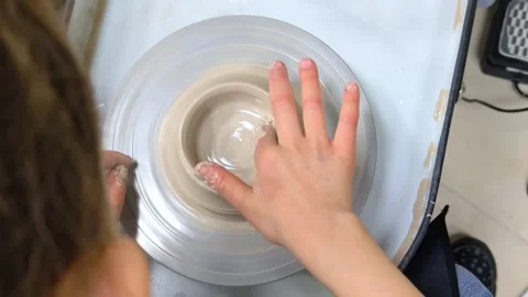 Child making ceramic vase on rotating pottery wheel at workshop. Creativity. Stock Footage 305638527