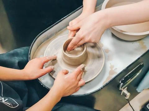 Child making ceramic vase on rotating pottery wheel at workshop. Creativity. Stock Photos