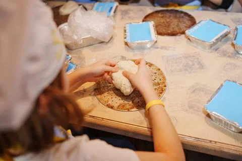 Child making dough during baking activity in a kitchen Stock Photos