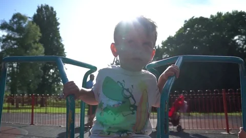 Child making funny faces on  the carousel Stock Footage 79976327