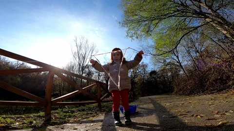 Child making giant soap bubbles in the park Stock Footage 134692559