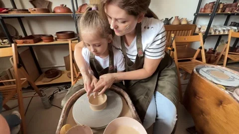 Child making a handmade clay pot in the workshop. Pottery lesson with master.  Stock Footage 277793113