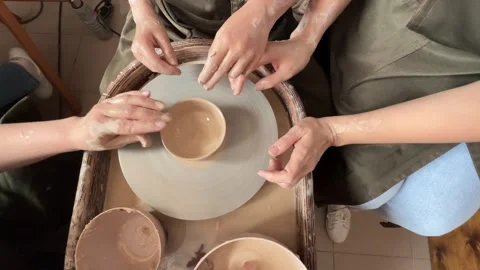 Child making a handmade clay pot in the workshop. Pottery lesson with master.  Stock Footage 277794231