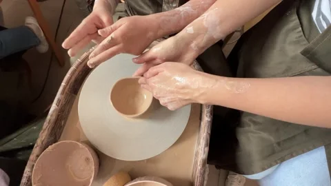 Child making a handmade clay pot in the workshop. Pottery lesson with master.  Stock Footage 277794463