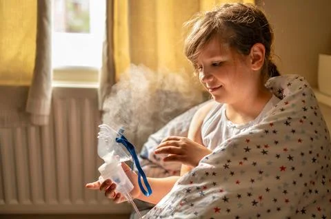 The child making an inhalation using a nebulizer. Stock Photos