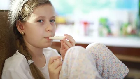  child measures the temperature of an electronic thermometer Stock Footage 69159245