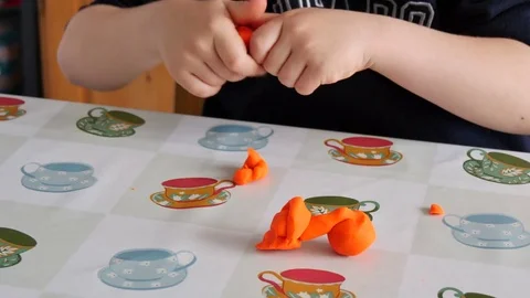 Child Modeling Orange Clay Stock Footage 80510960