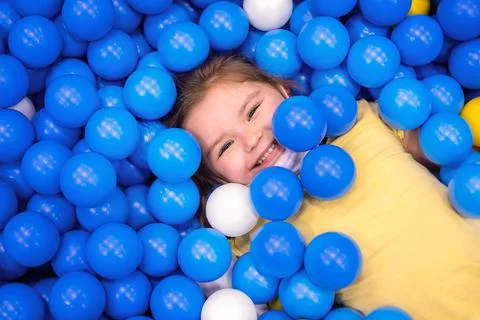 Child n multi-colored ball in playgroup Stock Photos