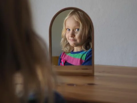 Child Observing Reflection in Mirror with a Smile Stock Photos