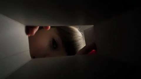 The child opens the box, looks into it and rejoices.  Stock Footage 235908019