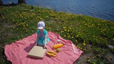Child opens cardboard box with pizza on seacoast. Stock Footage 112625442