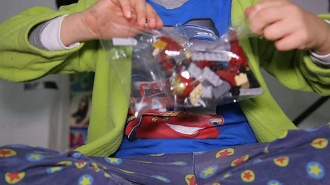 Child opens plastic bag with new interlocking plastic bricks toy Stock Footage 123508157