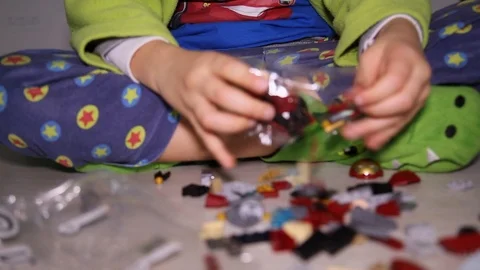Child opens plastic bag with new interlocking plastic bricks toy Stock Footage 123508240