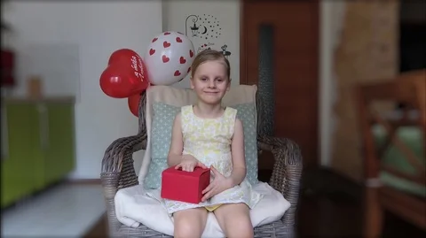 The child opens a present on birthday	 Video stock 105396573