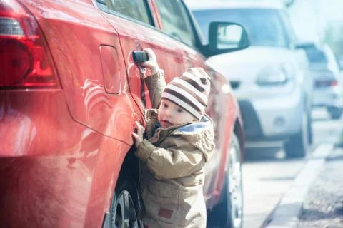 The child opens the red car Stock Photos
