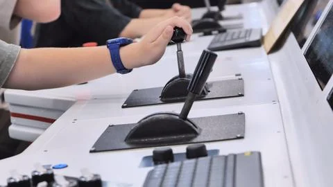 Child operating control panel levers at a robotics exhibition, engaging with Stock Photos