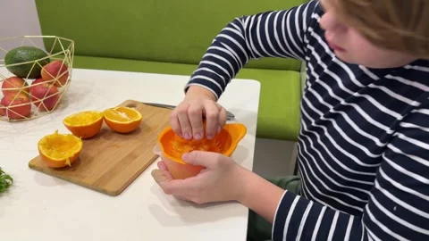 Child with oranges. Happy boy squeezed orange juice. Stock Footage 302920768