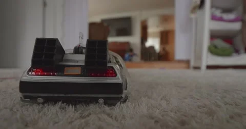 Child out of focus playing behind toy car slow motion Stockbeeldmateriaal 174083350