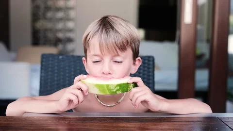 Child outdoor eating a refreshing slice of watermelon  Stock Footage 136814616