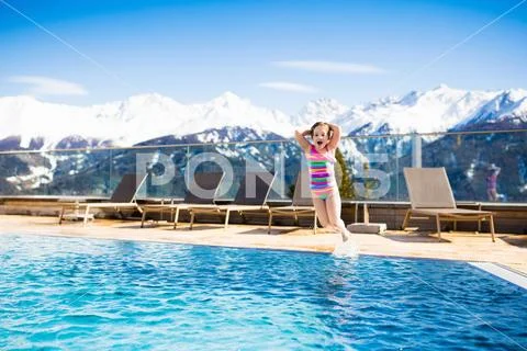 Child in outdoor swimming pool of alpine resort Stock Photos