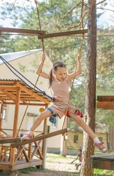 The child overcomes obstacles by walking along a rope track Foto stock